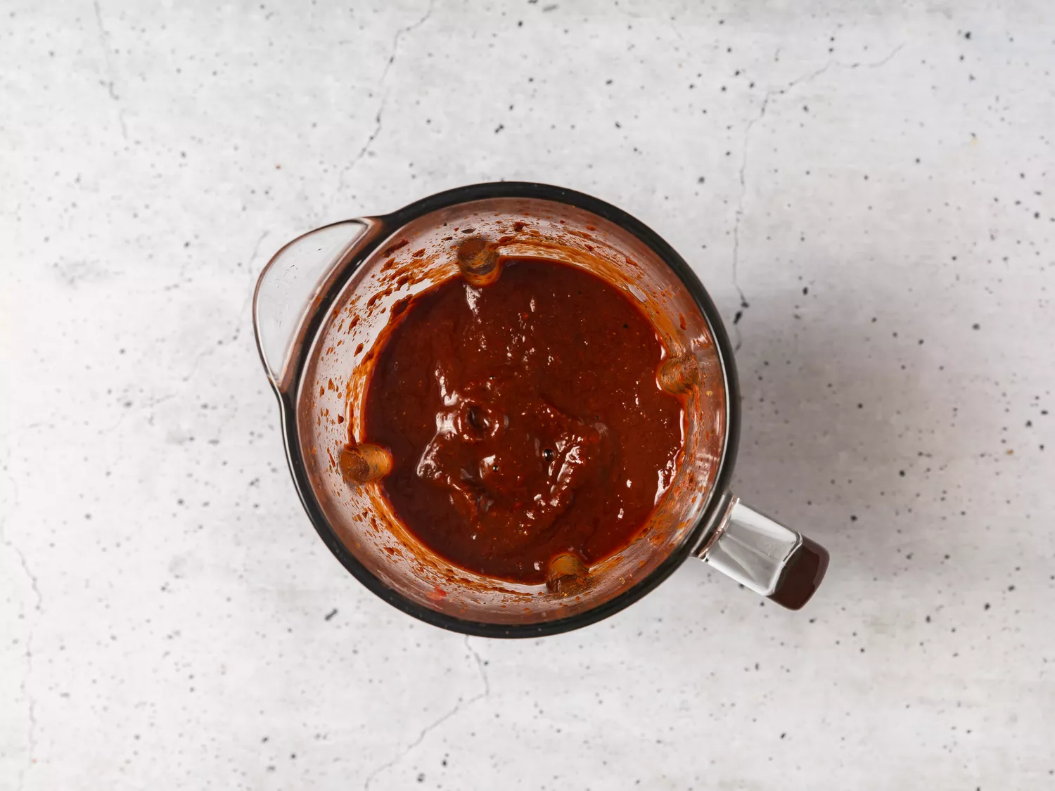A blender pitcher with smooth chili sauce
