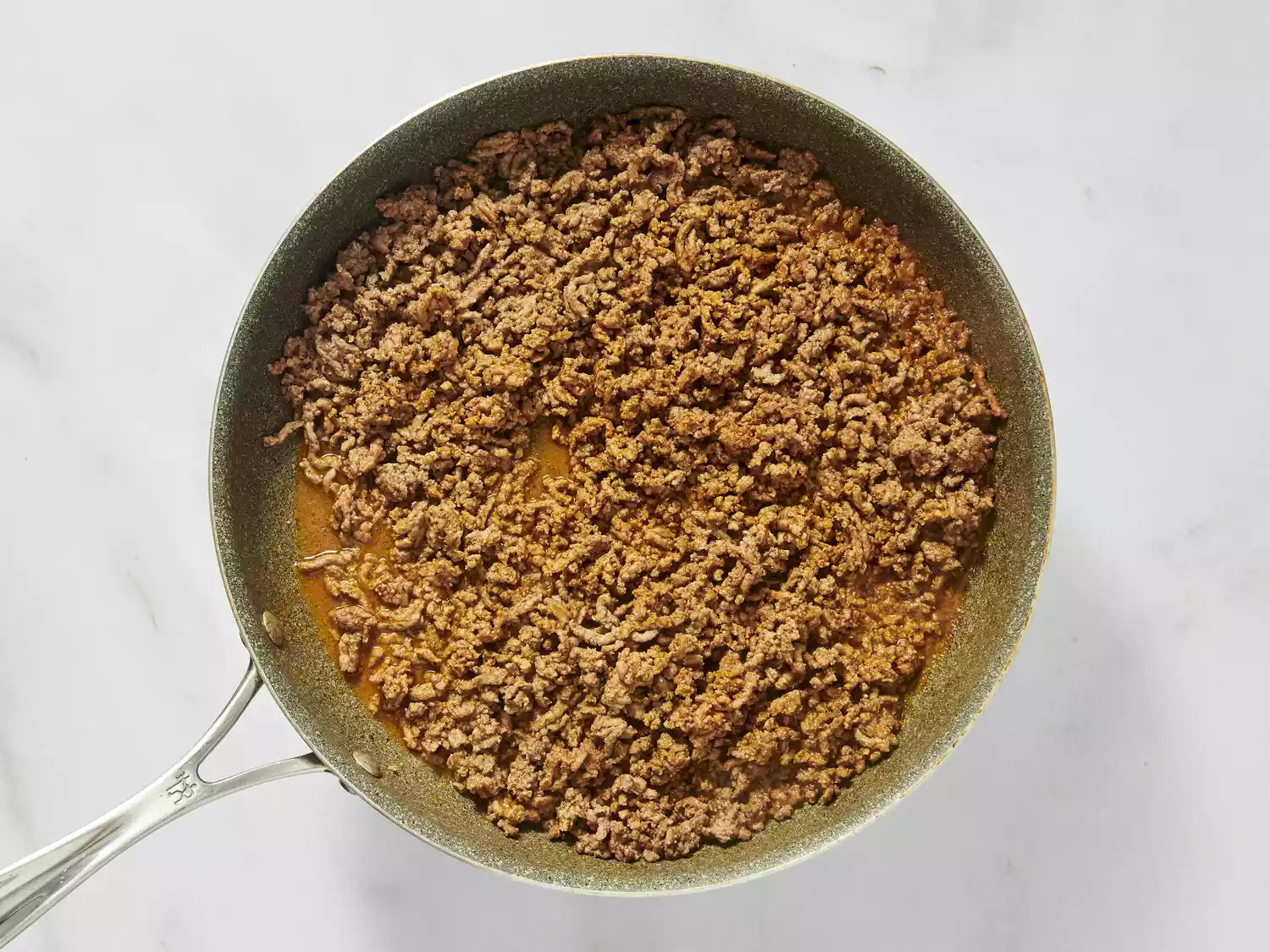 Cooked and seasoned ground beef in a frying pan.