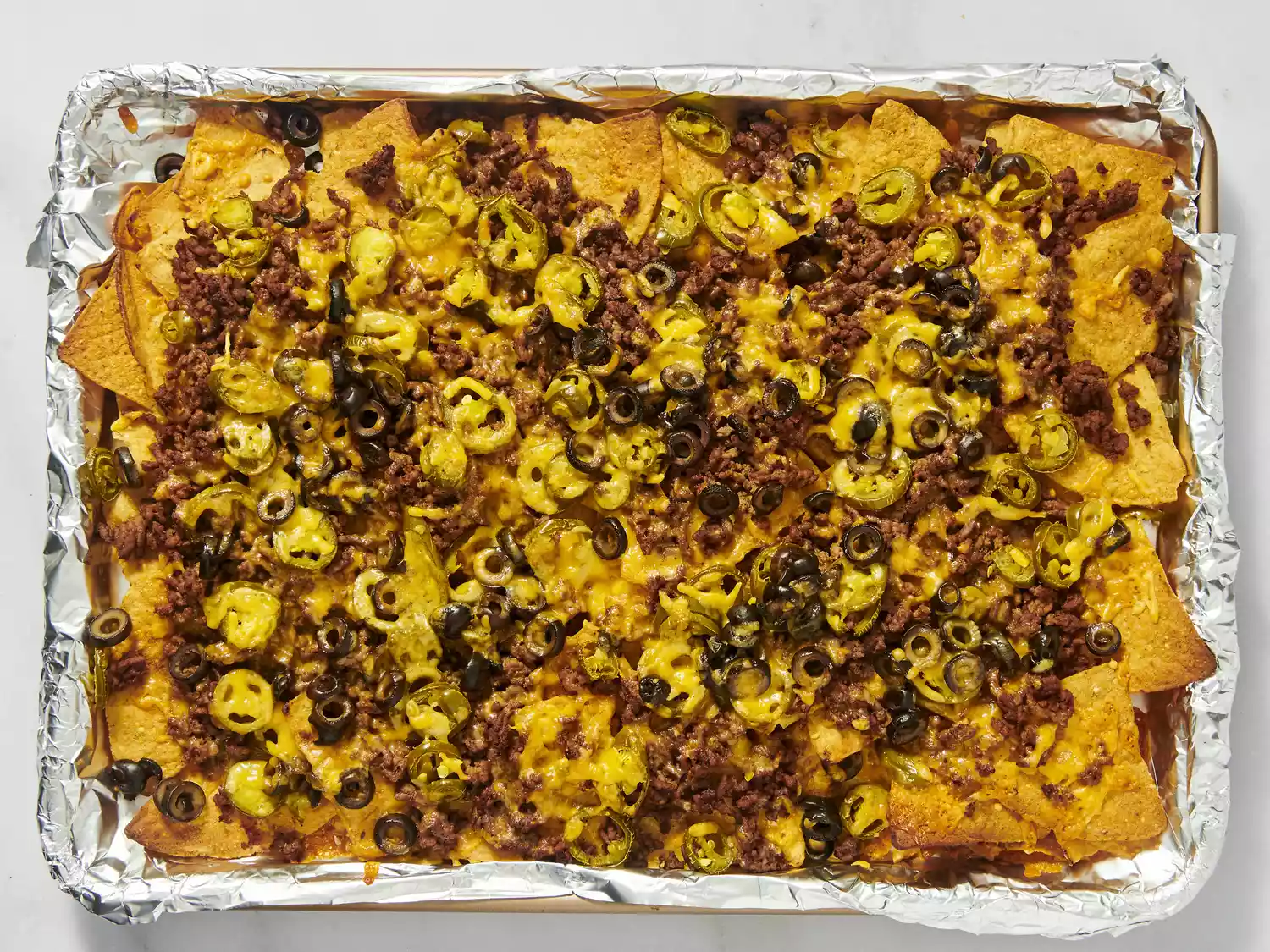 Freshly baked nachos with melted cheese, beef, and jalapeños.