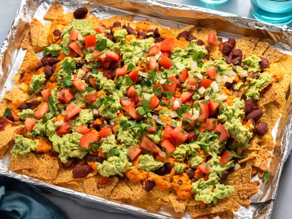Loaded nachos with guacamole, beans, and fresh toppings.