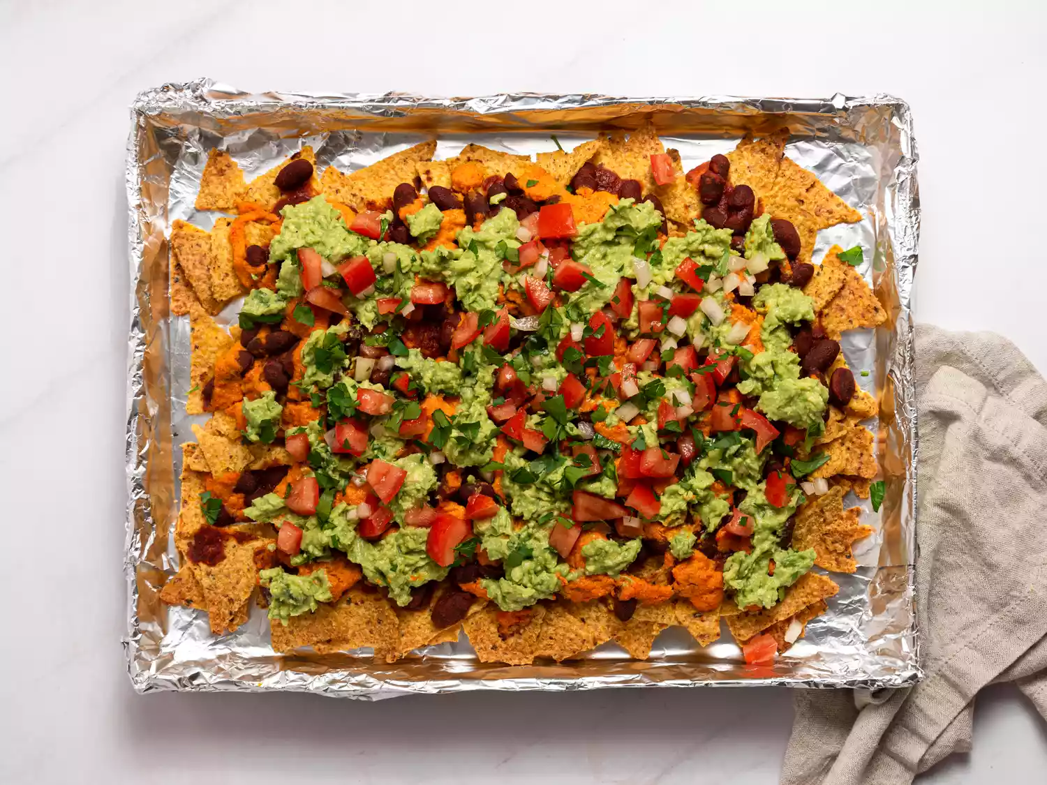 Loaded nachos with guacamole, beans, and fresh toppings.