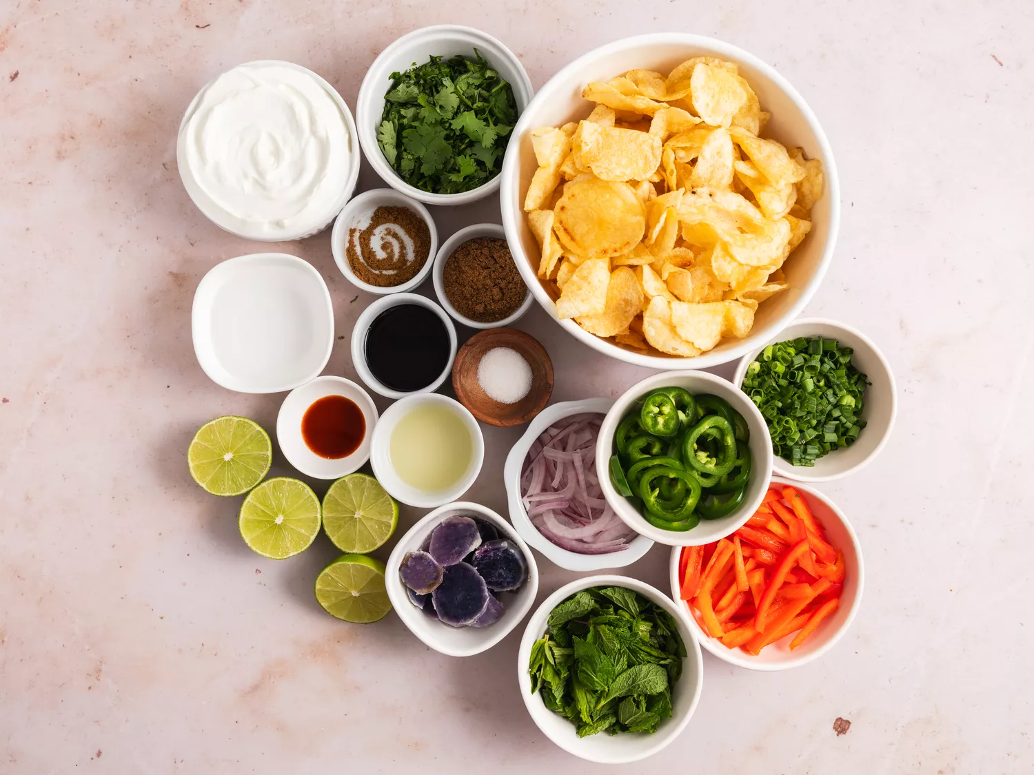 Various bowls filled with ingredients to make Indian Chaat-Inspired potato chip salad.