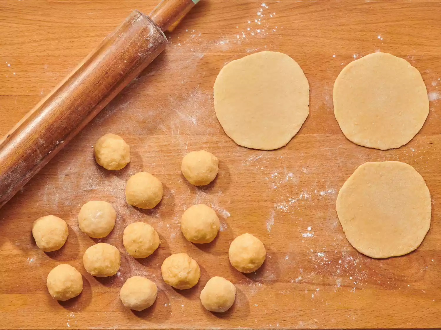  Rolled dough balls and flattened discs with a rolling pin.