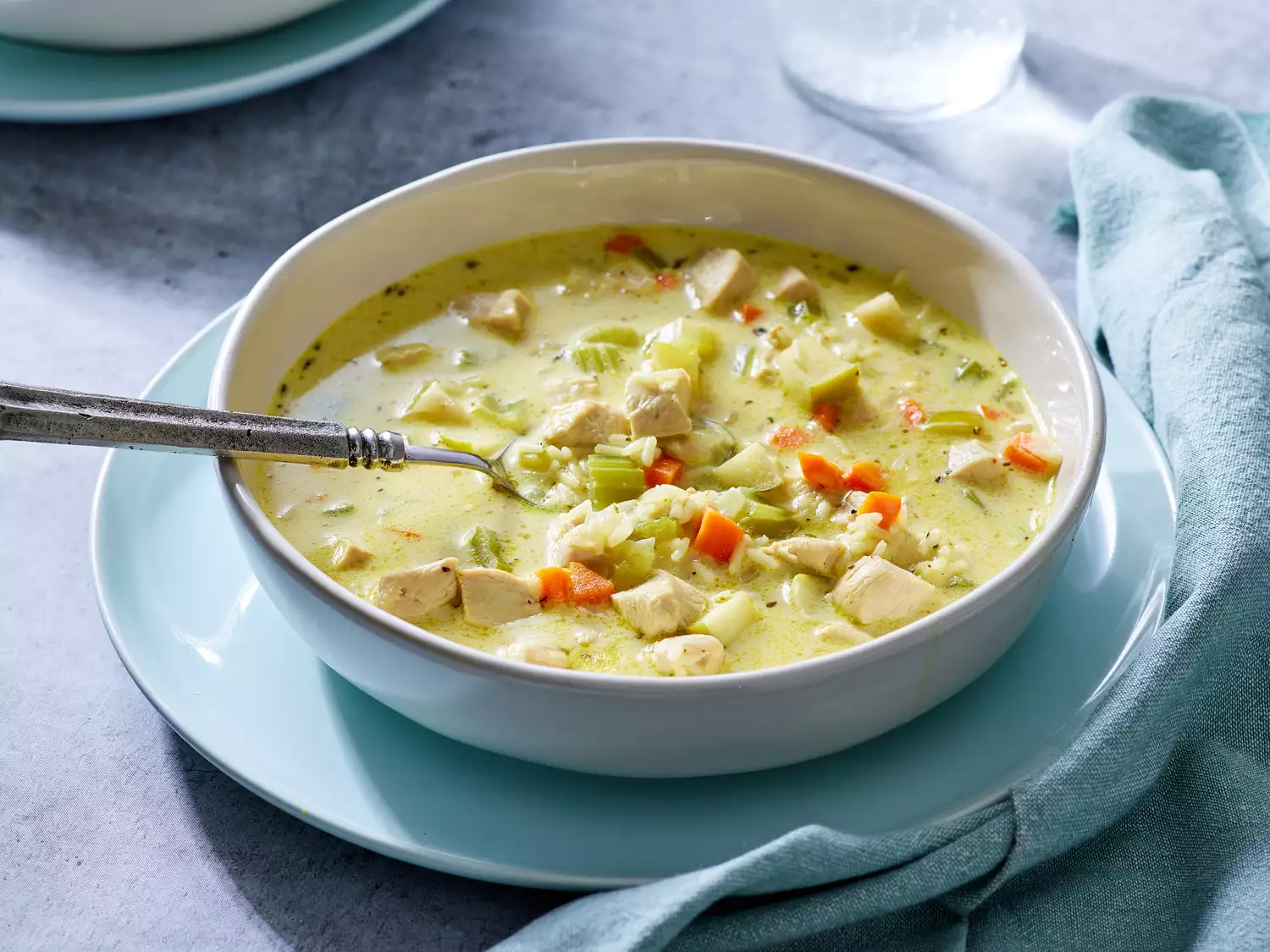 A bowl of creamy mulligatawny soup with chicken, celery, and carrots