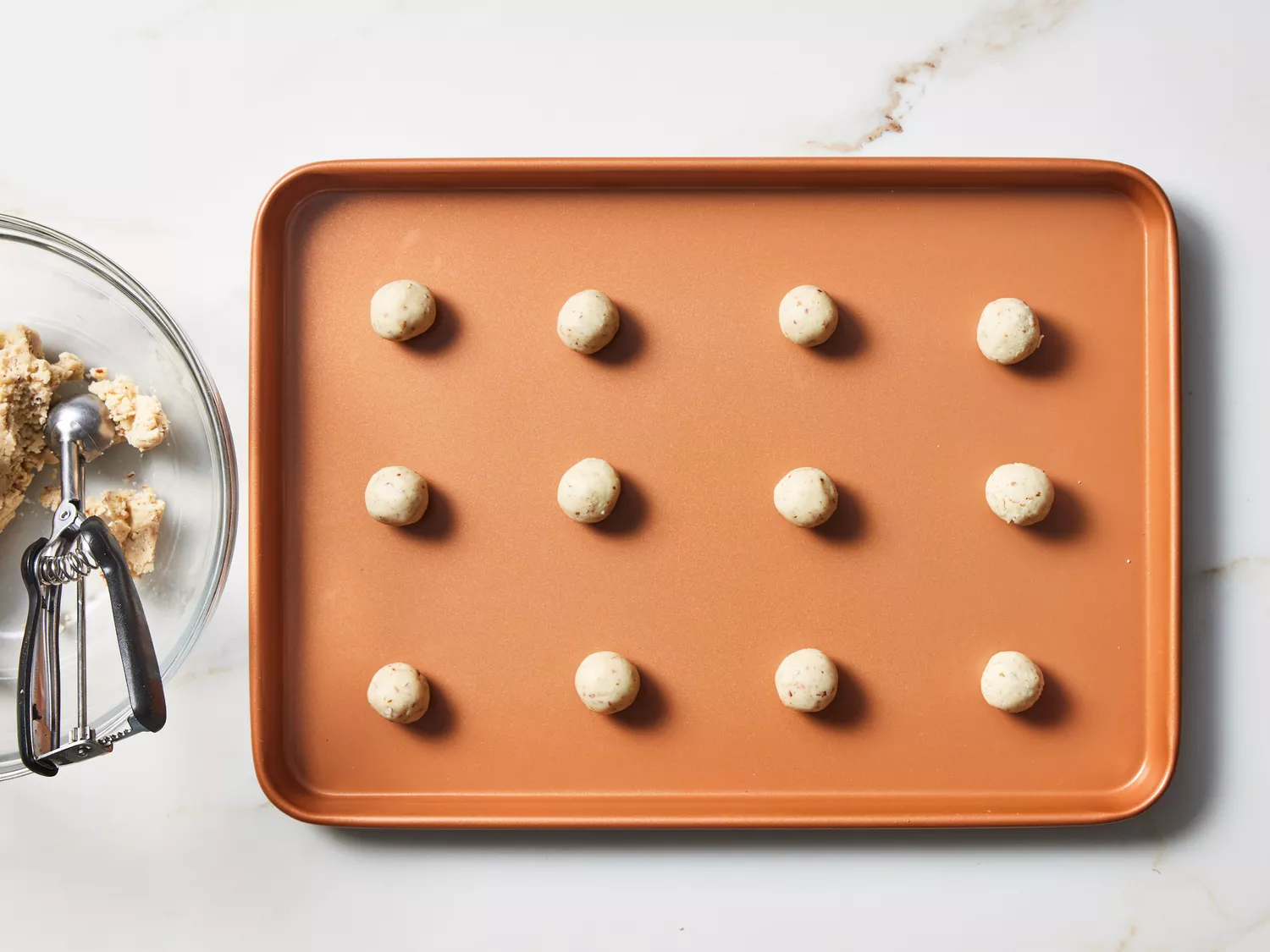 A baking sheet with evenly spaced balls of cookie dough