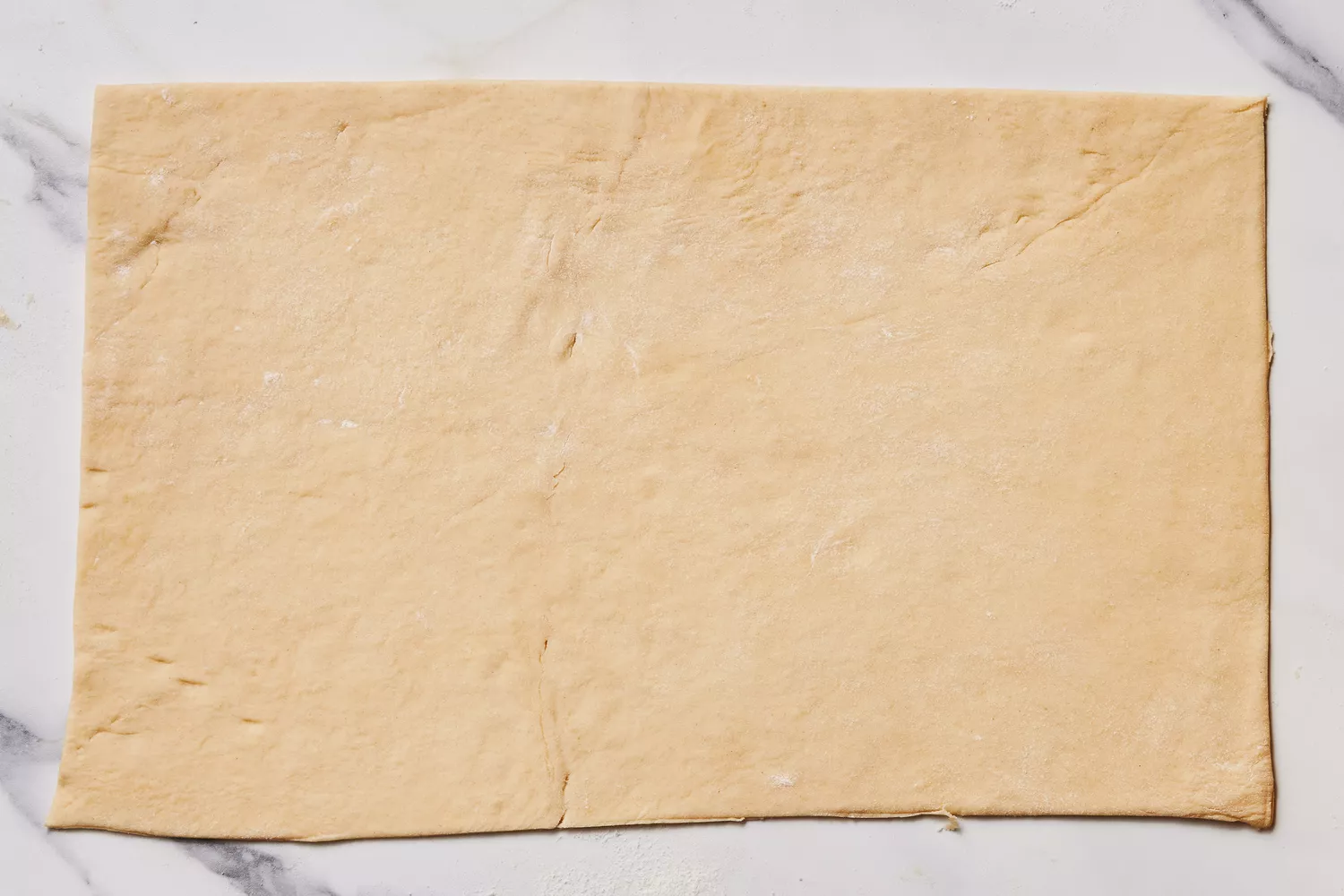 A rolled out, rectangular sheet of crescent dough