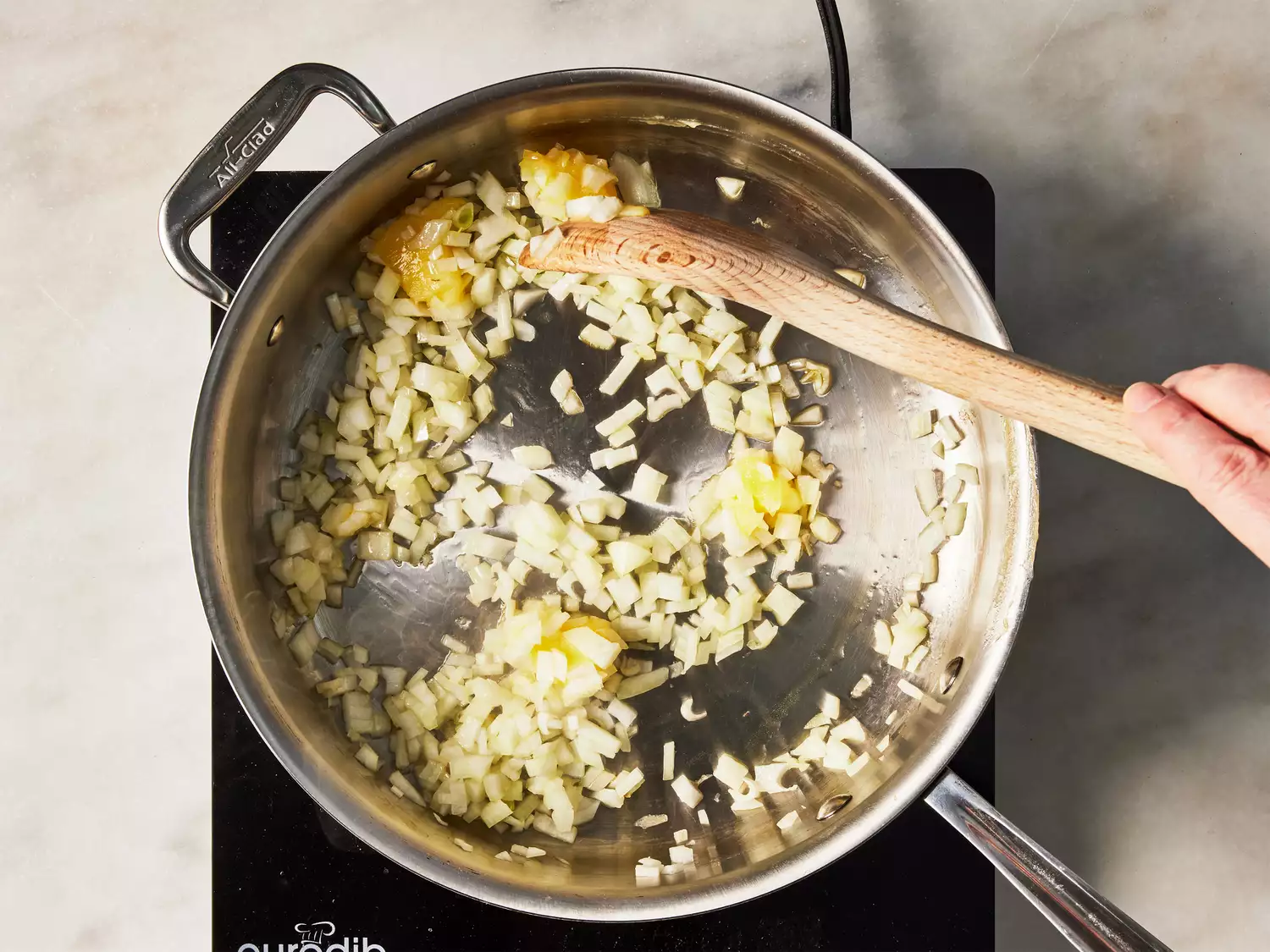 A large pan of chopped onions being cooked in ghee