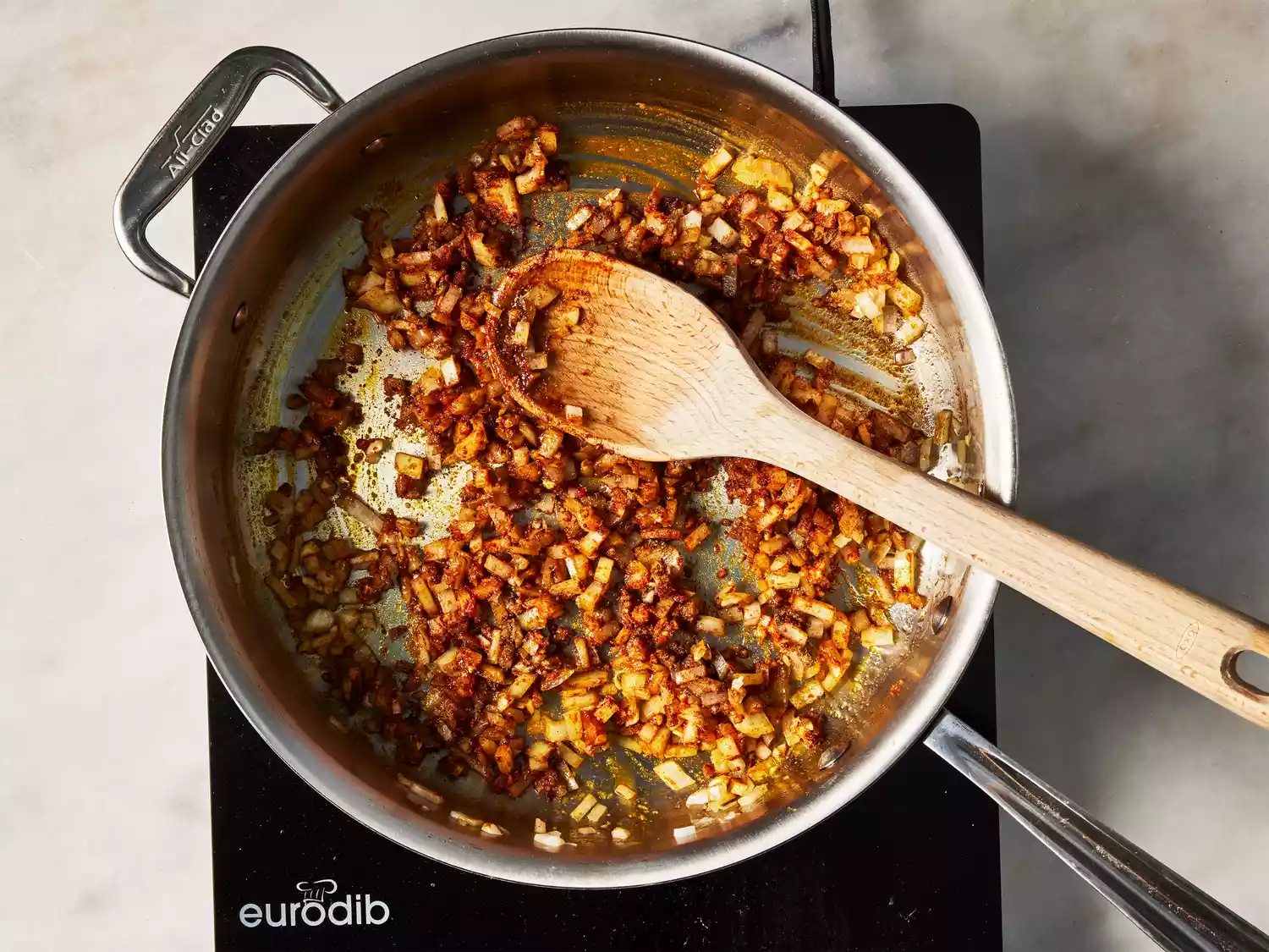 A pan of chopped onions and garlic cooking in spices