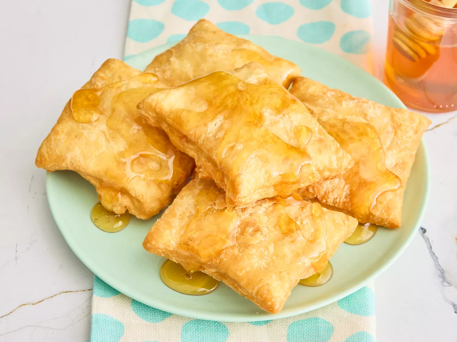 A plate of sopapillas drizzled with honey