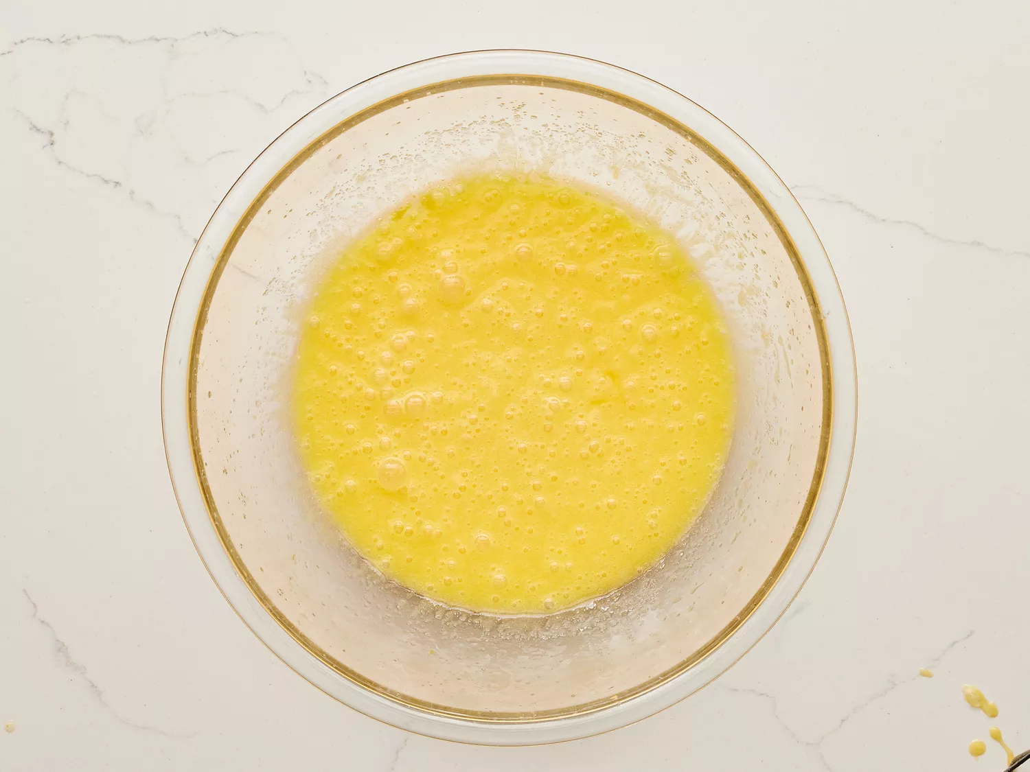 A glass bowl with butter, sugar, and eggs