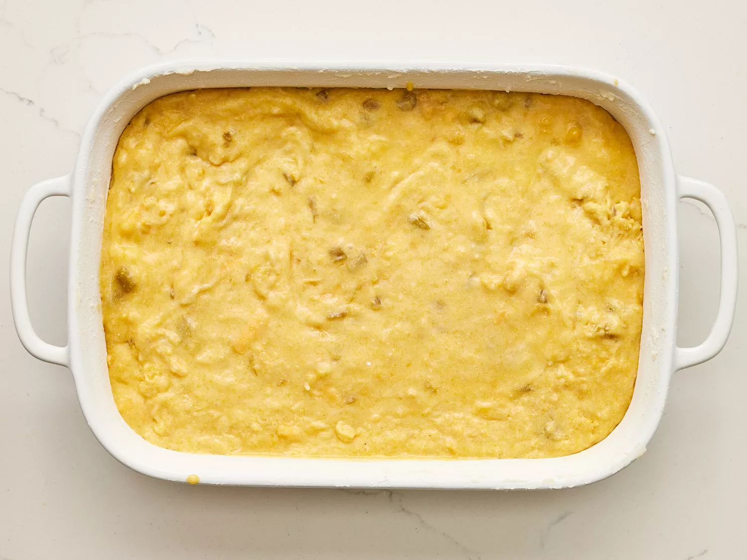 A baking dish with Mexican cornbread batter