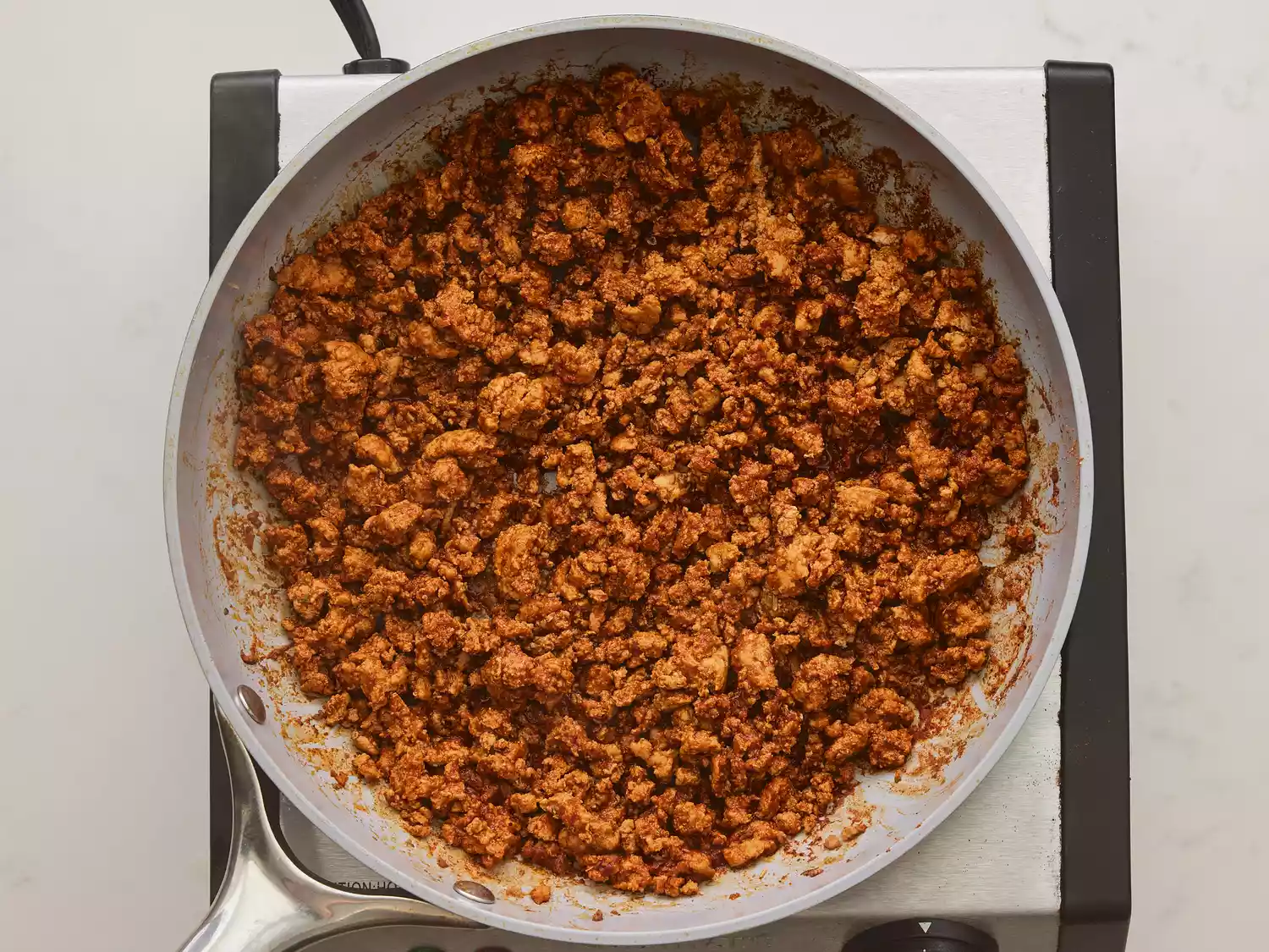 A large pan of seasoned ground turkey with water