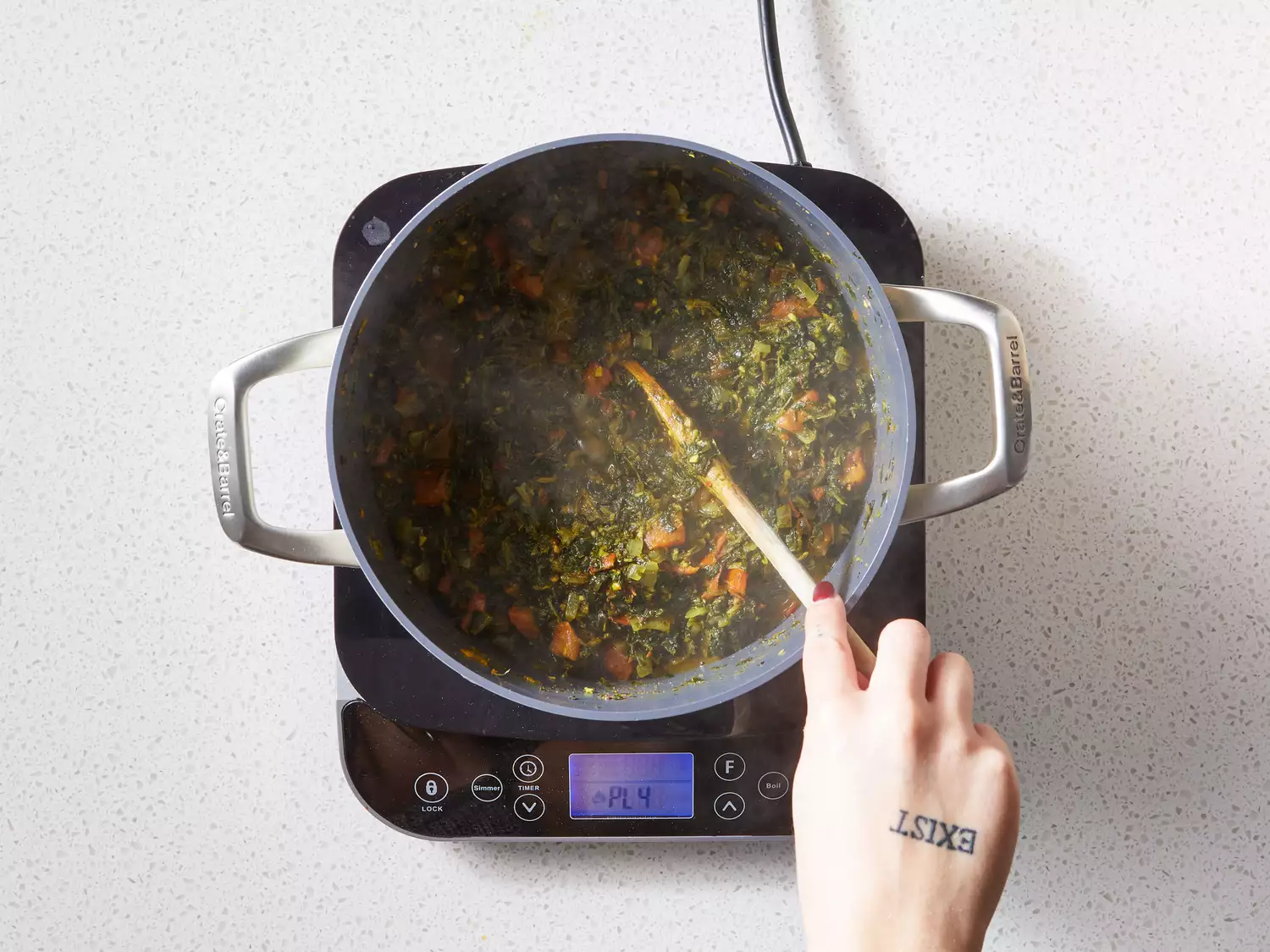A pot with chopped tomatoes, water, and spinach added to the onion-spice mixture