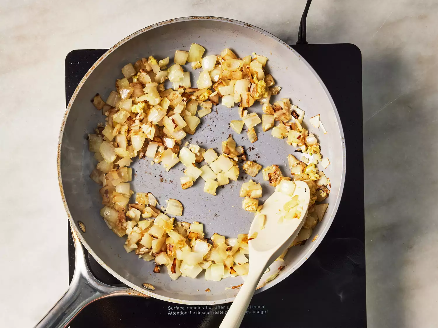 A pan of browned garlic, ginger, and onions