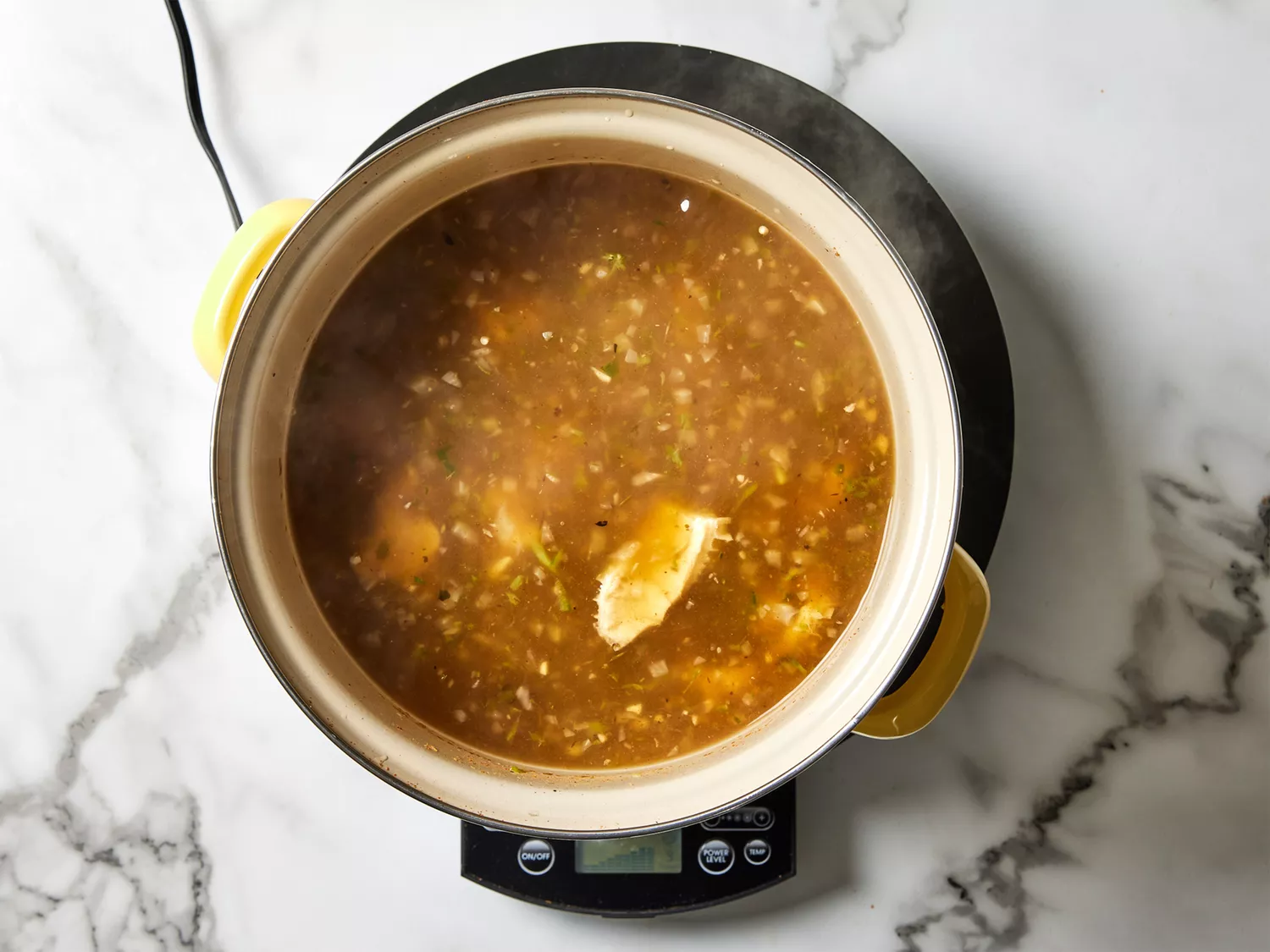 A pot of simmered tripe in broth with the chile mixture added