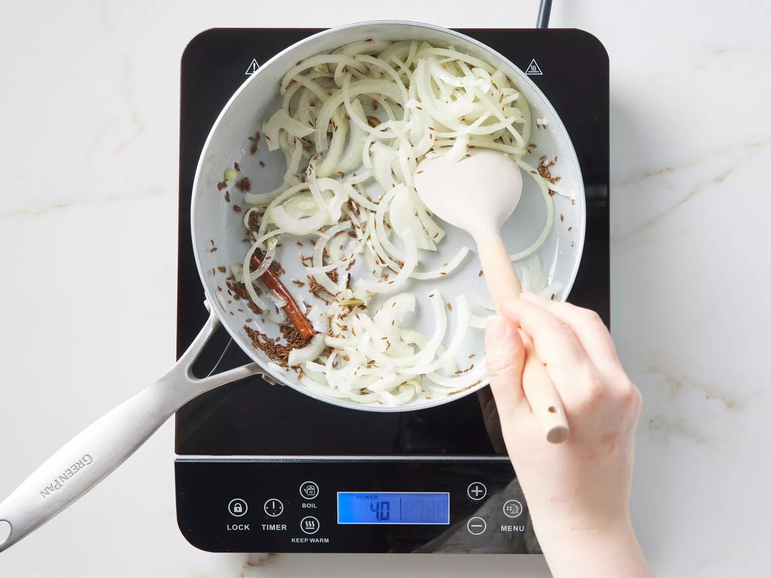 A pot with toasted slices and sliced onion being stirred with a spatula
