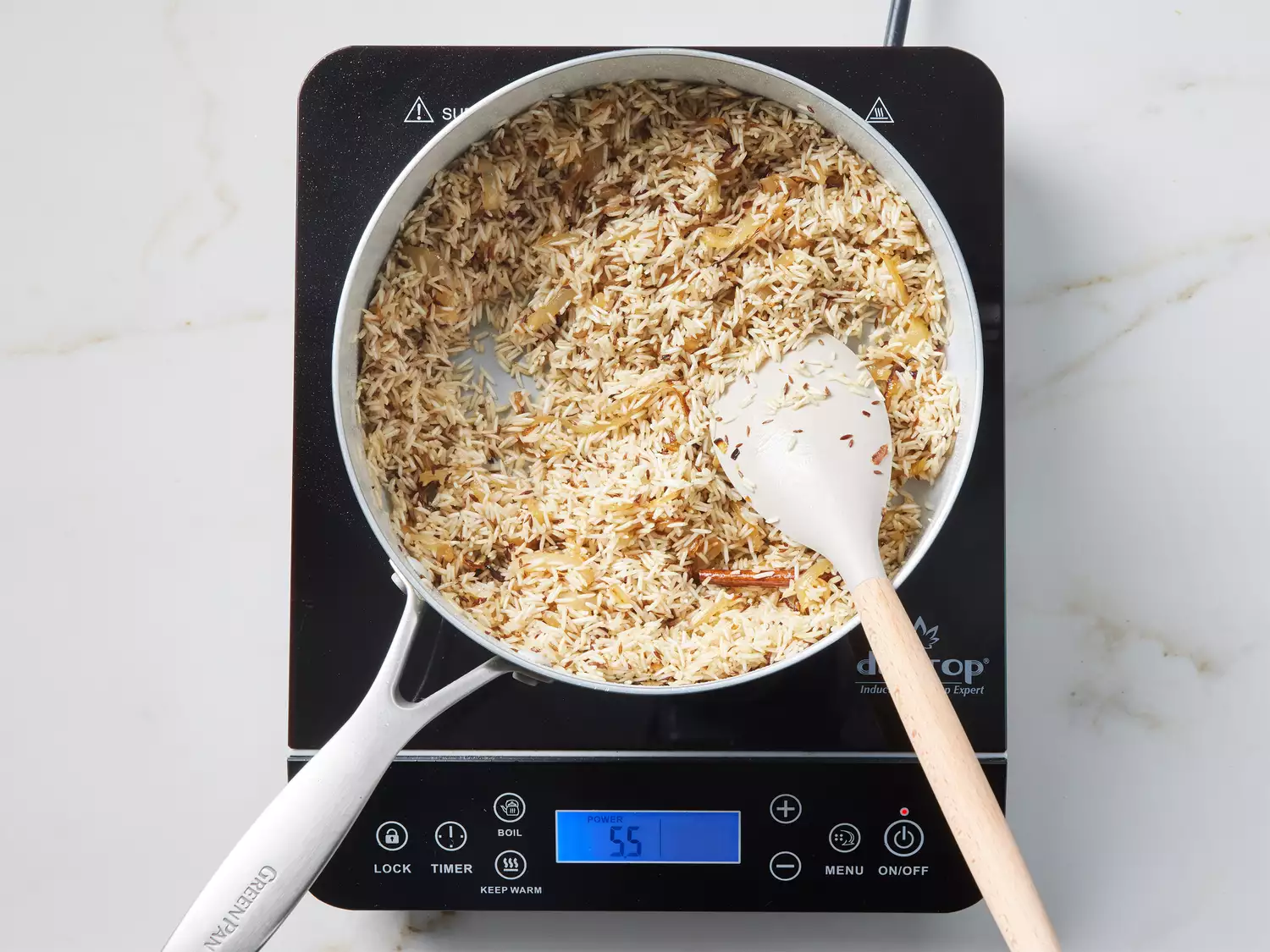 A pot of soaked basmati rice with caramelized onions and toasted spices