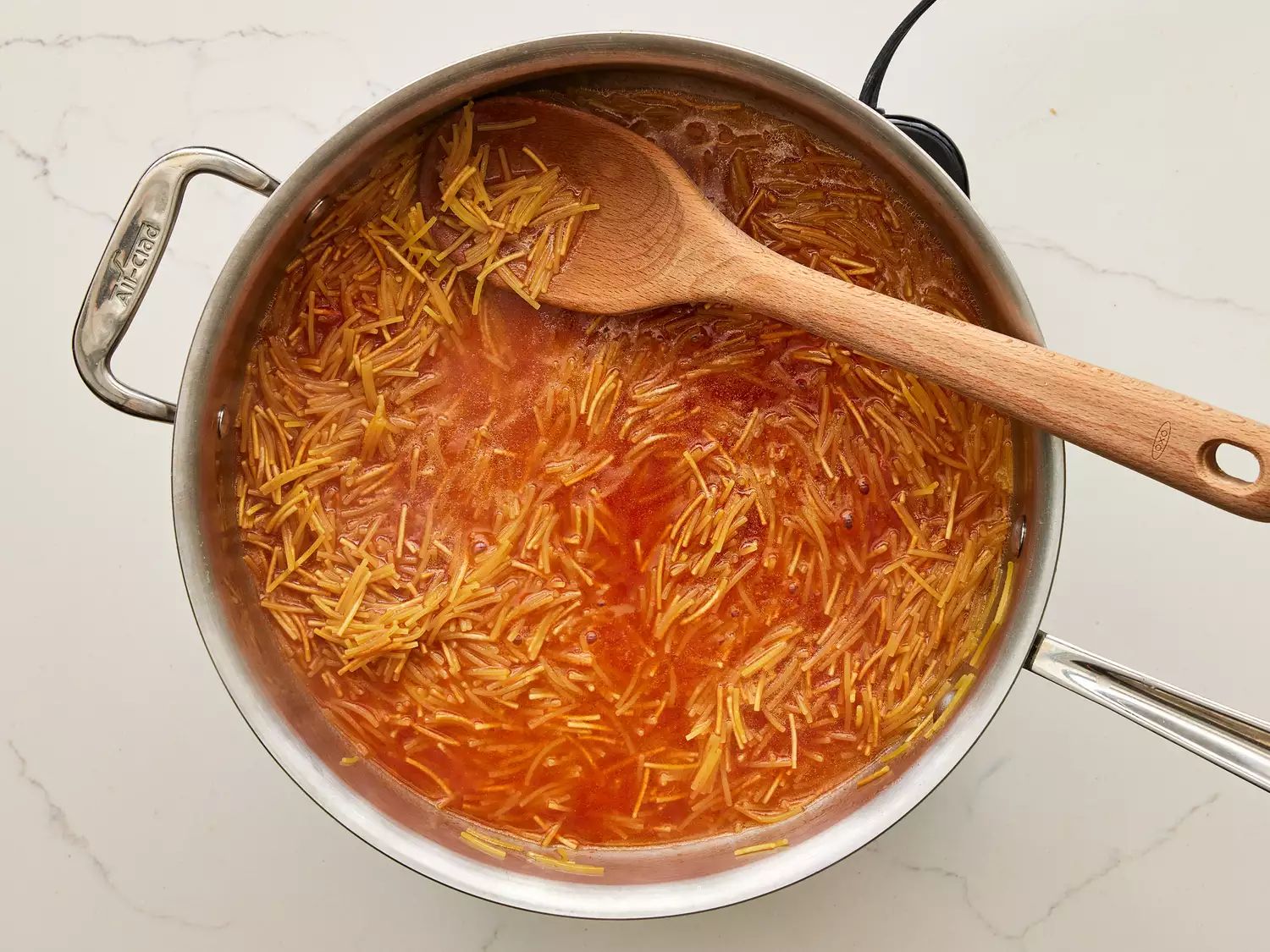 A pan of Fideo pasta in water and tomato sauce