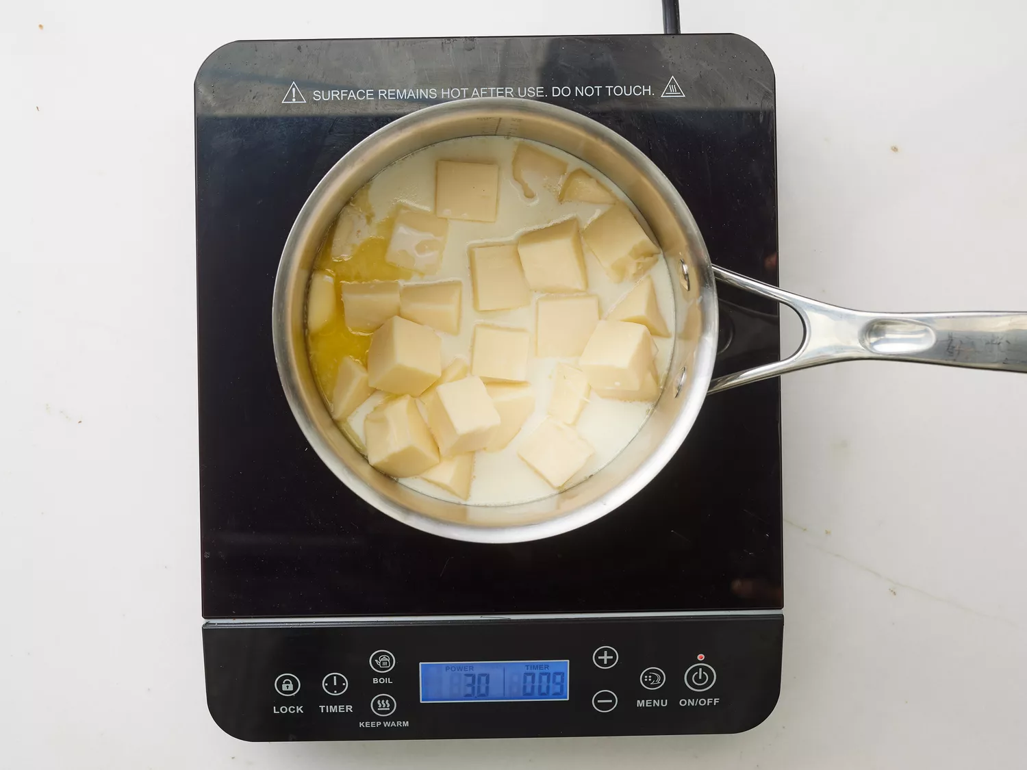 A saucepan with cheese, butter, and milk