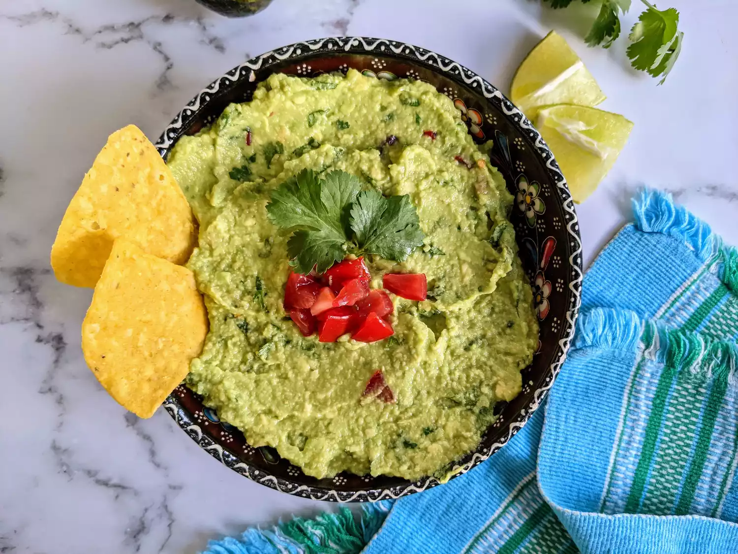 Bowl of guacamole with chips sticking out of it