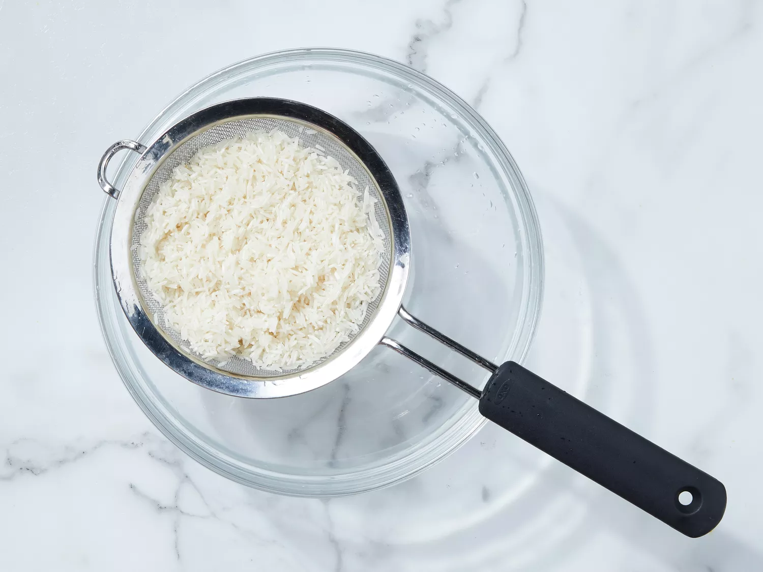 rice washed and draining in a colander. 