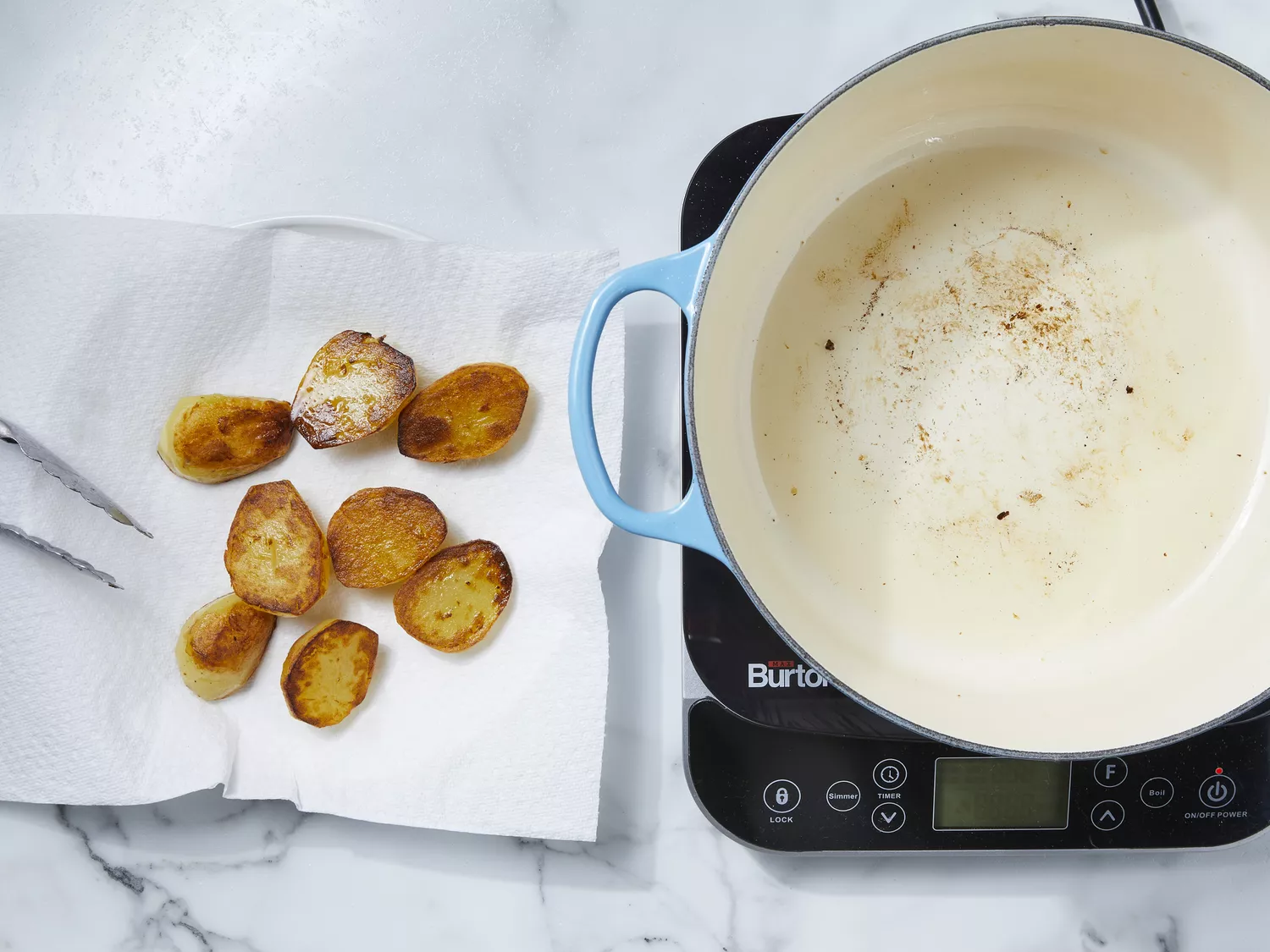 potatoes fried in hot oil until lightly browned, then placed on a paper towel-lined plate to drain.