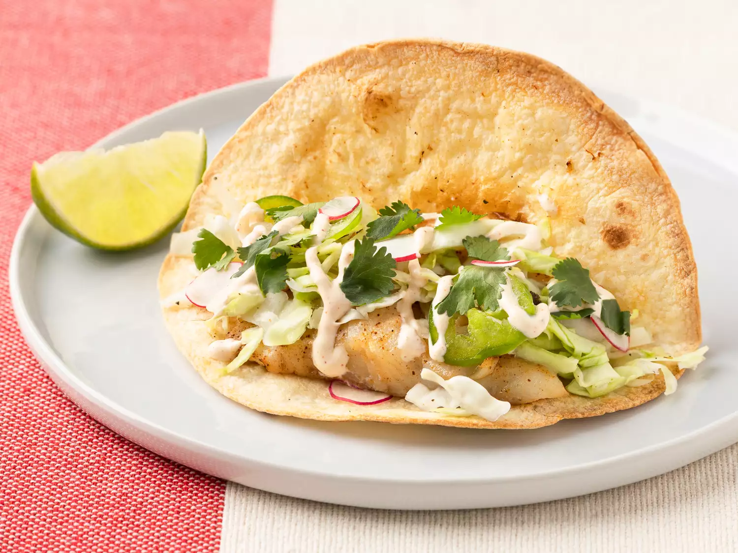 Baked puffy fish tacos on a white plate.