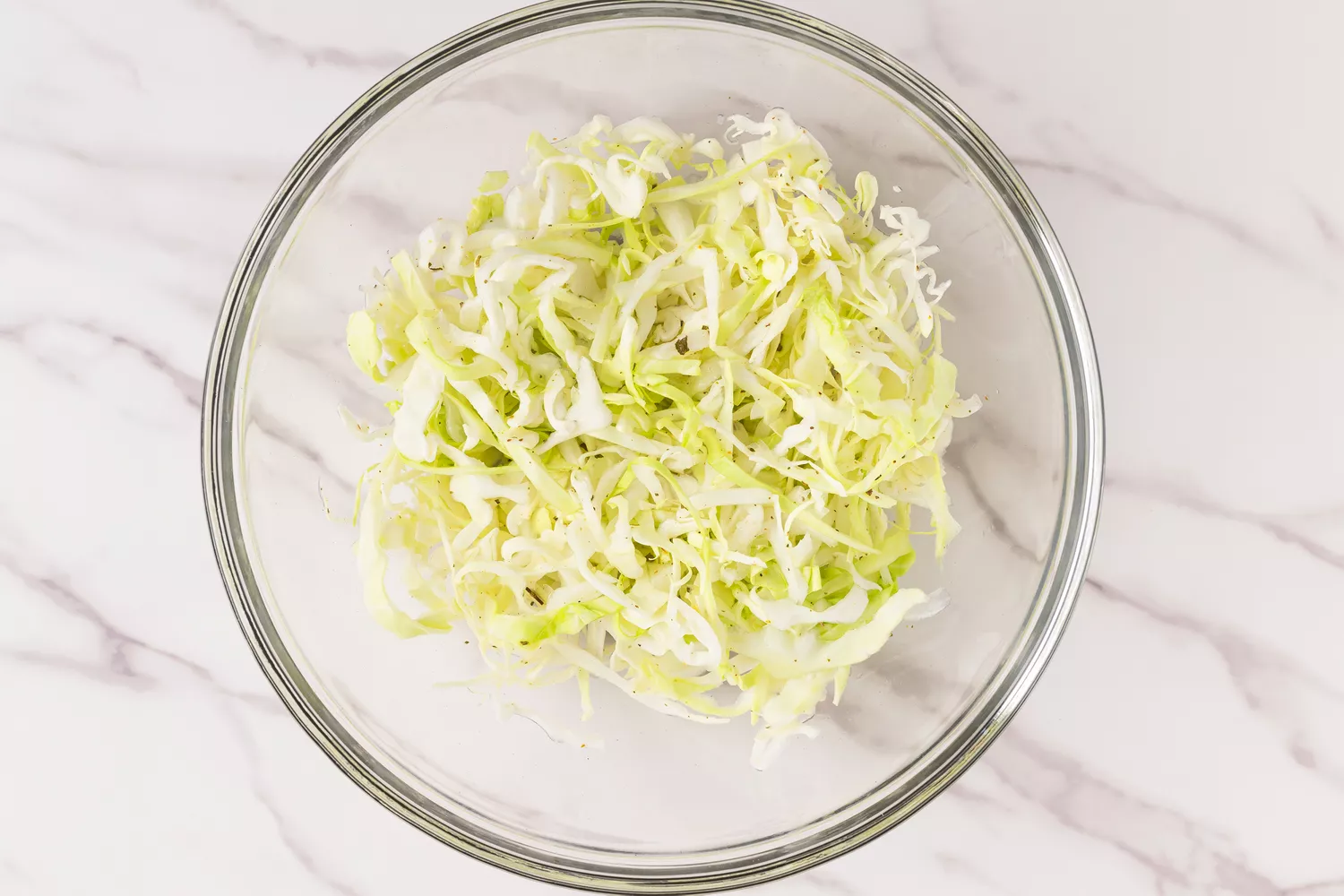 Shredded cabbage in a glass bowl. 