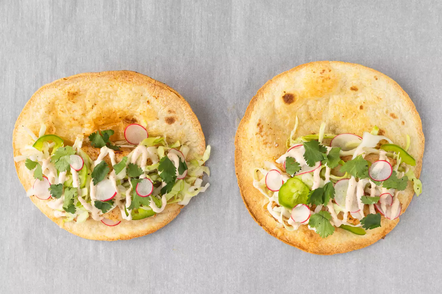 Baked fish topped with vegetables on tortilla shells. 